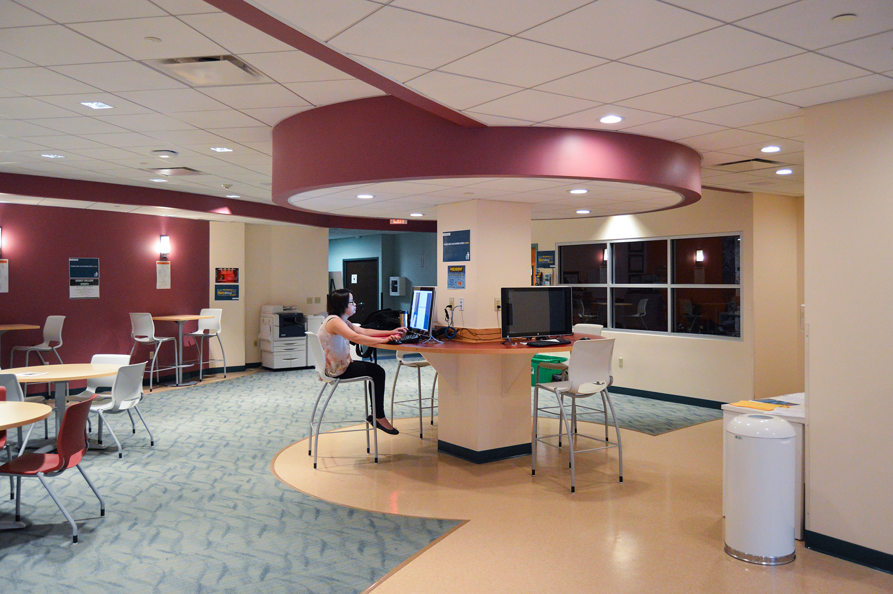 Quincy College student center seating area with high tables